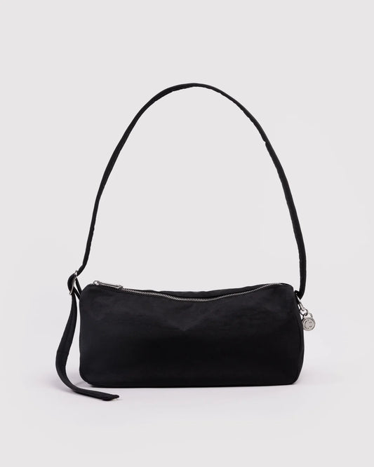 Black handbag with a strap on a light gray background