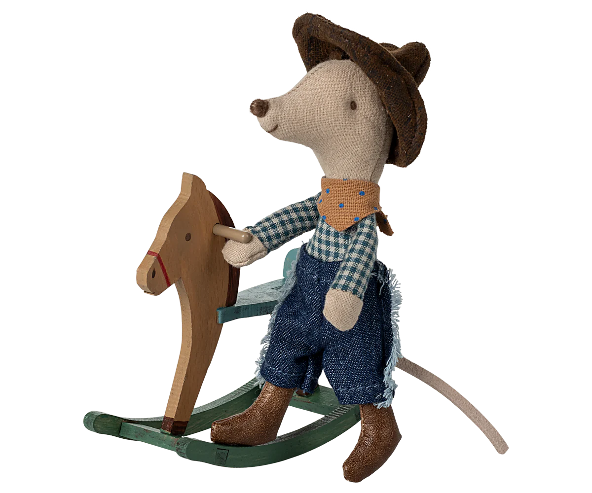 Toy mouse in cowboy outfit riding a wooden rocking horse on a white background