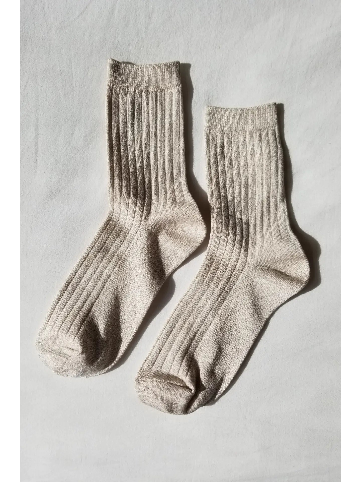 Pair of beige socks on a light gray background