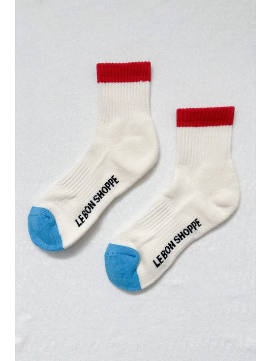 Two white socks with red and blue accents on a light gray background