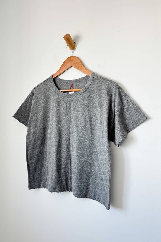 Gray t-shirt on a wooden hanger against a white background