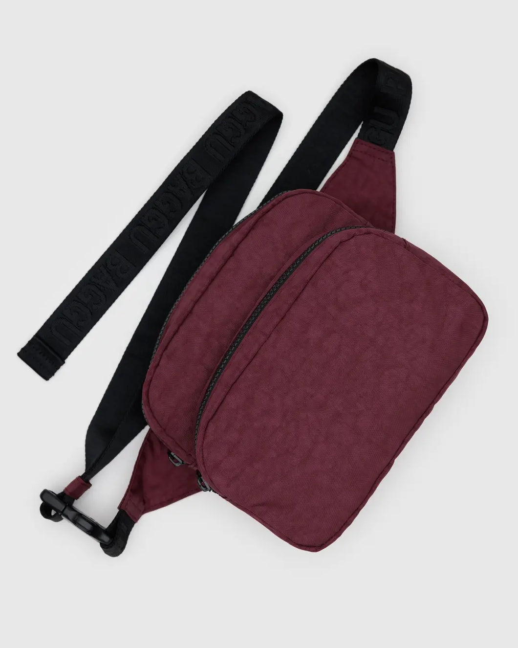 Baggu maroon waist bag with a black strap on a light gray background