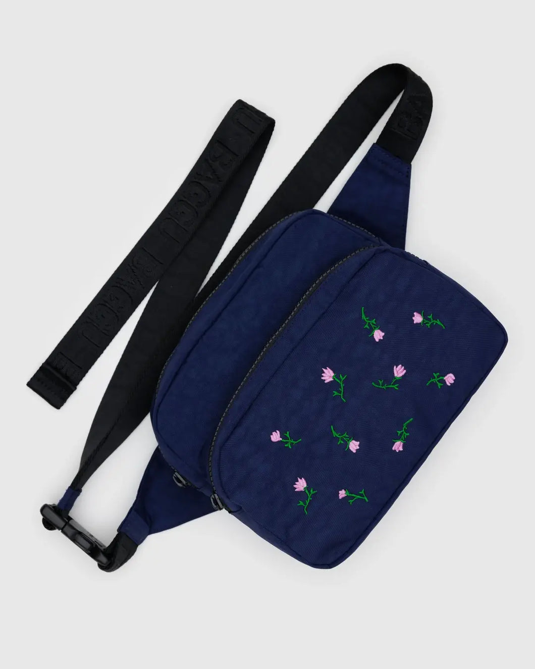Baggu navy blue waist bag with floral embroidery on a light gray background